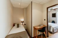 a bedroom with a bed and a desk and a mirror at Hôtel L&#39;Iroko The Originals City in Aix-les-Bains