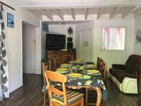 een eetkamer met een tafel en een bank bij Maison d'Hôtes L'Escale Du Loup Blanc in Maringes