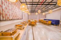 un restaurante con mesas y sillas y un sofá azul en The Mohua - A Boutique Hotel, en Ranchi