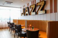 Un restaurante con mesas y sillas y un gran cartel de Kaze. en Kyriad - Créteil - Bonneuil-sur-Marne, en Bonneuil-sur-Marne