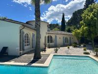 a house with a swimming pool and a palm tree at Central Valbonne Villa in Valbonne