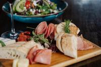 a plate of food with meat and a bowl of salad at Snow King Resort Luxury Condominiums in Jackson
