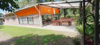 a patio with a picnic table and an orange building at Finca Huallpamarjka in Salta