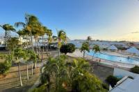- une vue sur un complexe avec une piscine et des palmiers dans l&#39;établissement Appartement Le Golfeur, à Saint-François