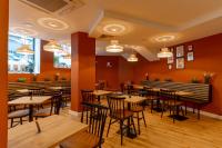 un restaurante con mesas y sillas de madera y paredes de color naranja en Westlight Lisboa Madalena, en Lisboa