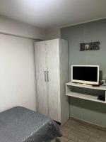 a bedroom with a bed and a cabinet with a television at Hostel Tuzla in Tuzla