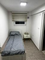 a small bedroom with a bed and a window at Hostel Tuzla in Tuzla