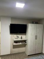 a living room with a tv and a white cabinet at Hostel Tuzla in Tuzla