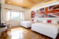 a bedroom with two beds and a desk and a window at Spring Villa in Dongshan