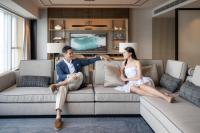 a man and a woman sitting on a couch at Four Seasons Hotel Hong Kong in Hong Kong