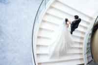 a bride and groom on a staircase at their wedding at Four Seasons Hotel Hong Kong in Hong Kong