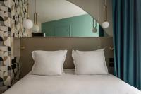 a bed with two white pillows in a room at Arc Elysées in Paris