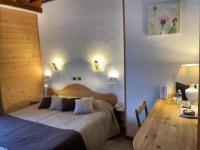 a bedroom with a bed and a table and lights at Hotel de Bourgogne in Saulieu