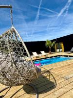 a hammock on a deck next to a pool at Evasion tropicale in Bretteville-sur-Odon
