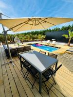 a patio with a table and an umbrella next to a pool at Evasion tropicale in Bretteville-sur-Odon