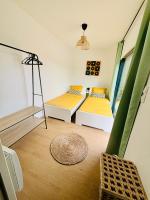a room with two beds and a window at Evasion tropicale in Bretteville-sur-Odon