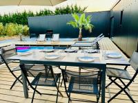 a table and chairs on a patio with a pool at Evasion tropicale in Bretteville-sur-Odon