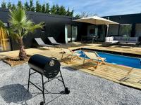 a barbecue grill sitting on a patio next to a pool at Evasion tropicale in Bretteville-sur-Odon