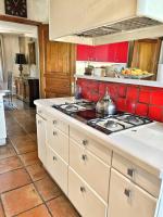 a kitchen with a stove top and a red wall at Magnifique villa avec Piscine Vue mer in Sanary-sur-Mer
