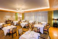 Un restaurante con mesas y sillas blancas y una lámpara de araña. en Killeen Castle, en Dunsany