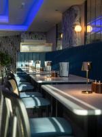 a bar with blue chairs and tables in a restaurant at Marian Resort And Spa in Prestatyn