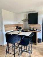 a kitchen with a table and two chairs in a kitchen at Magnifique appartement 2&#47;4 pers - Le Saint Leo in Saint-Léonard-des-Bois