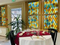 ein Tisch mit Weingläsern darauf und Buntglasfenstern in der Unterkunft Hôtel de la Croix Blanche in Villiers-Saint-Benoît