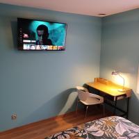 a bedroom with a desk and a tv on the wall at Maison calme&#47;Chambre privée&#47;Clim+TV&#47;Pétit dejeuner inclu&#47;tout confort in Nevers