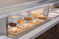 Beach Park Resort - Suites في أكويراز: علبة عرض مليئة بمختلف أنواع الحلويات