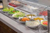 Beach Park Resort - Suites في أكويراز: بوفيه مليء بمختلف انواع الخضار في الطاسات