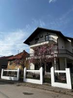 a white house with a fence in front of it at Hostel Tuzla in Tuzla