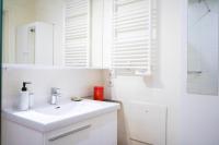 a white bathroom with a sink and a mirror at Cozy 58 m near Butte-aux-Cailles in Paris