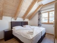a bedroom with a large bed in a room with wooden ceilings at Haus Lilyan in Donnersbachwald