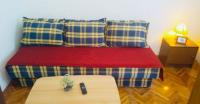 a bed with blue and yellow pillows and a table at Apartments by the sea Jezera, Murter - 5123 in Jezera