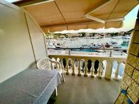 a balcony with a table and chairs and a marina at Apartments by the sea Jezera, Murter - 5123 in Jezera