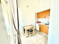 a small kitchen with a wooden table and chairs at Apartments by the sea Jezera, Murter - 5123 in Jezera
