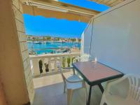 a balcony with a table and chairs and a view of the water at Apartments by the sea Jezera, Murter - 5123 in Jezera