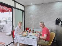 Due persone sedute a tavola mangiando cibo di Golden Rose Premium Hotel Hanoi a Hanoi