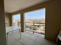 a room with a balcony with a table and a large window at San José in Juvignac