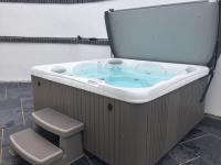 a jacuzzi tub with a toilet sitting next to it at Relax in style at my stunning Holywell Beach home in Holywell Bay