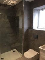 a bathroom with a shower with a toilet and a sink at Relax in style at my stunning Holywell Beach home in Holywell Bay