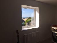 a window in a room with a guitar next to it at Relax in style at my stunning Holywell Beach home in Holywell Bay