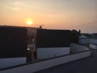 a view of the sunset from the roof of a building at Relax in style at my stunning Holywell Beach home in Holywell Bay