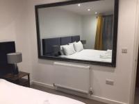 a bedroom with a large mirror and a bed at Relax in style at my stunning Holywell Beach home in Holywell Bay