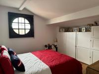 Un dormitorio con una cama roja y blanca y una ventana en Villa basquaise avec piscine, en Andernos-les-Bains