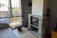 a living room with a fireplace and a window at Casita Planes Surroca in Bourg-Madame