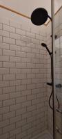 a white tiled shower with a shower head at B&amp;B Bon Vivant in Brinay