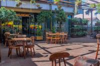 un grupo de mesas y sillas frente a una tienda en Vinetea Hotel, en Kampala