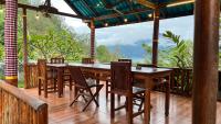un restaurant avec des tables et des chaises en bois sur une terrasse dans l'établissement Dewangga Mountain View, à Bangli