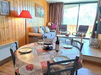 a living room with a table with a bottle of wine at Appartement Pra-Loup, 3 pièces, 6 personnes - FR-1-165A-54 in Uvernet